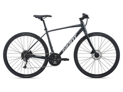 A GunMetal Black Giant bicycle with a road bike setup, including a chain drive, brakes, and wheels.